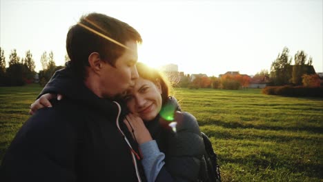 pareja abrazándose al atardecer en un parque