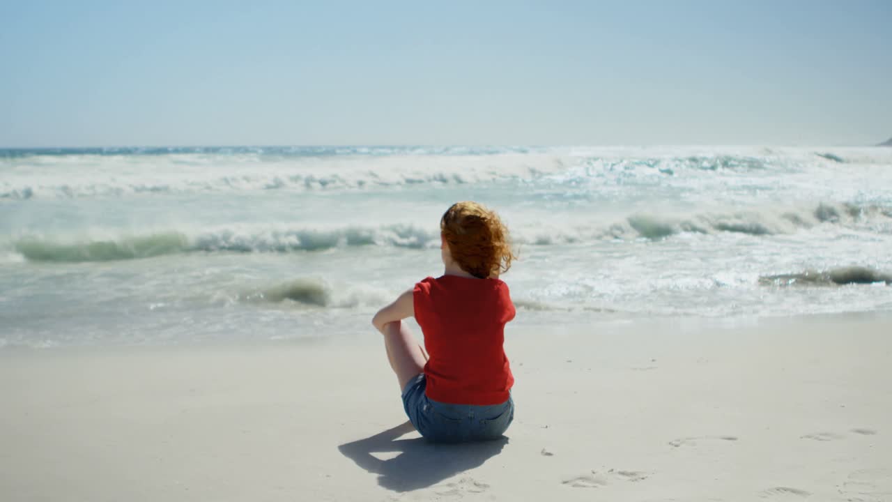 모래 위에 앉아서 바다를 바라보는 여자 4k