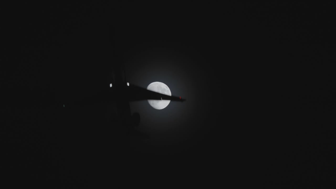Airplane Silhouette Flying Past Moon At Night
