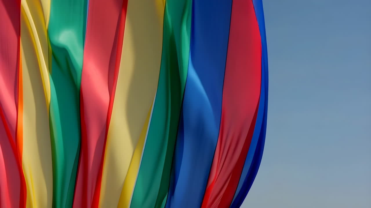 Colorful Flowing Fabric Against Blue Sky