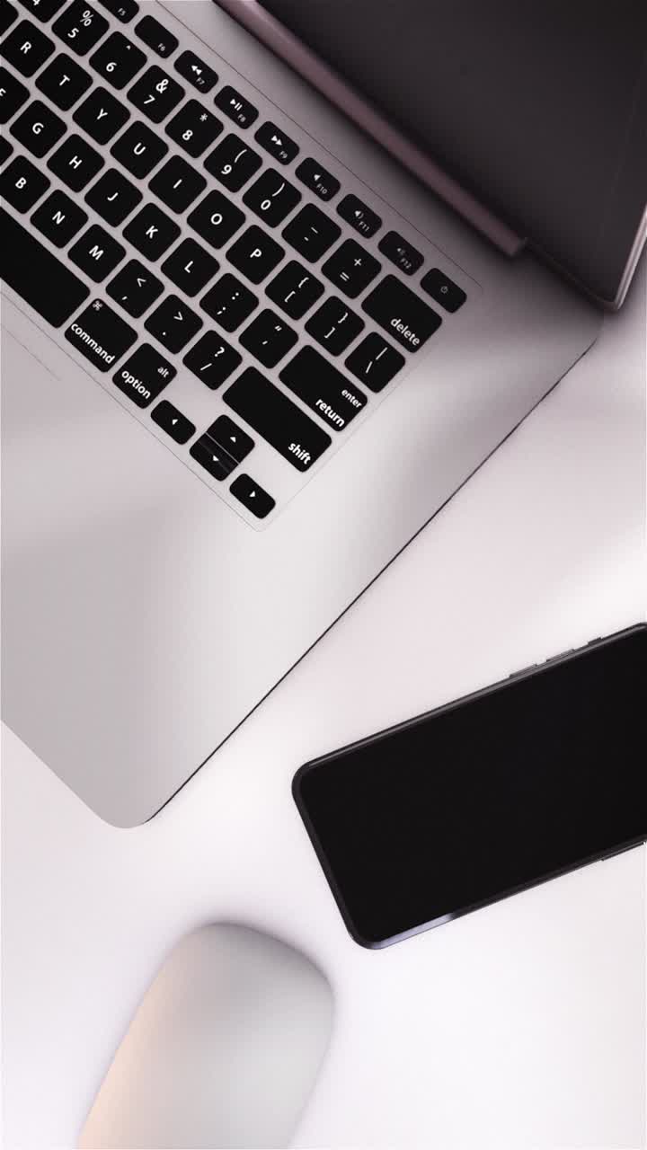 Oversigtsbillede af bærbar computer, smartphone og mus på et hvidt skrivebord