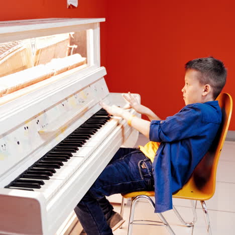 young boy playing piano. how does the piano