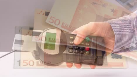 Animation-of-euro-banknotes-falling-over-hand-of-caucasian-man-holding-payment-terminal