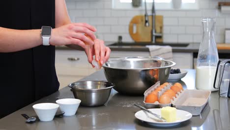 mujer rompiendo un huevo en un tazón en la cocina 4k
