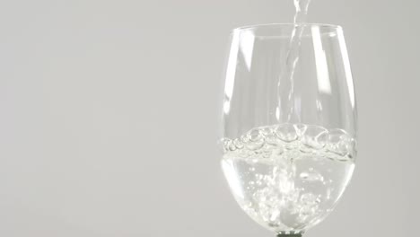 White-wine-falling-in-glass-against-white-background