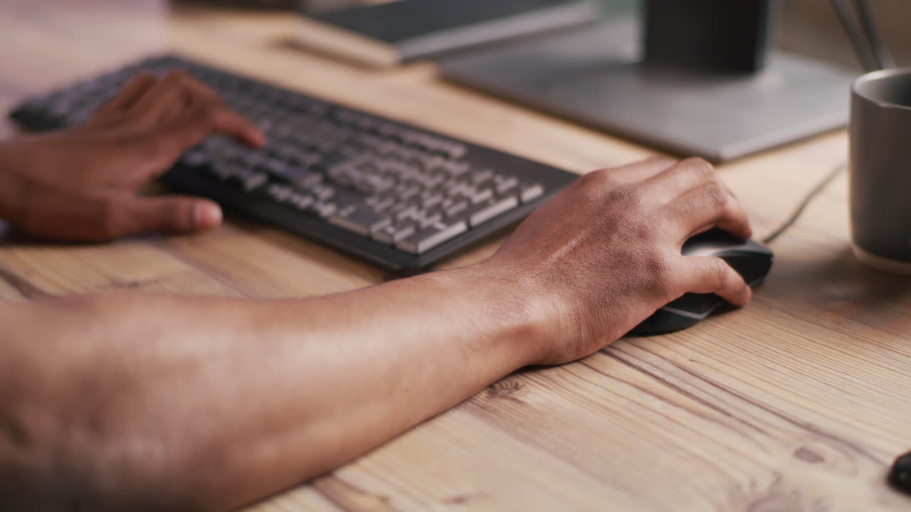 Person Typing on Keyboard and Using a Mouse