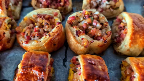 assorted pastries arranged on tray with toppings, nuts, and glazed finish