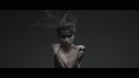a woman dressed as mother nature moves slowly in a dance-like motion