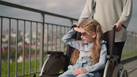 chica con parálisis cerebral disfruta de la vista de la ciudad cubriendo los ojos