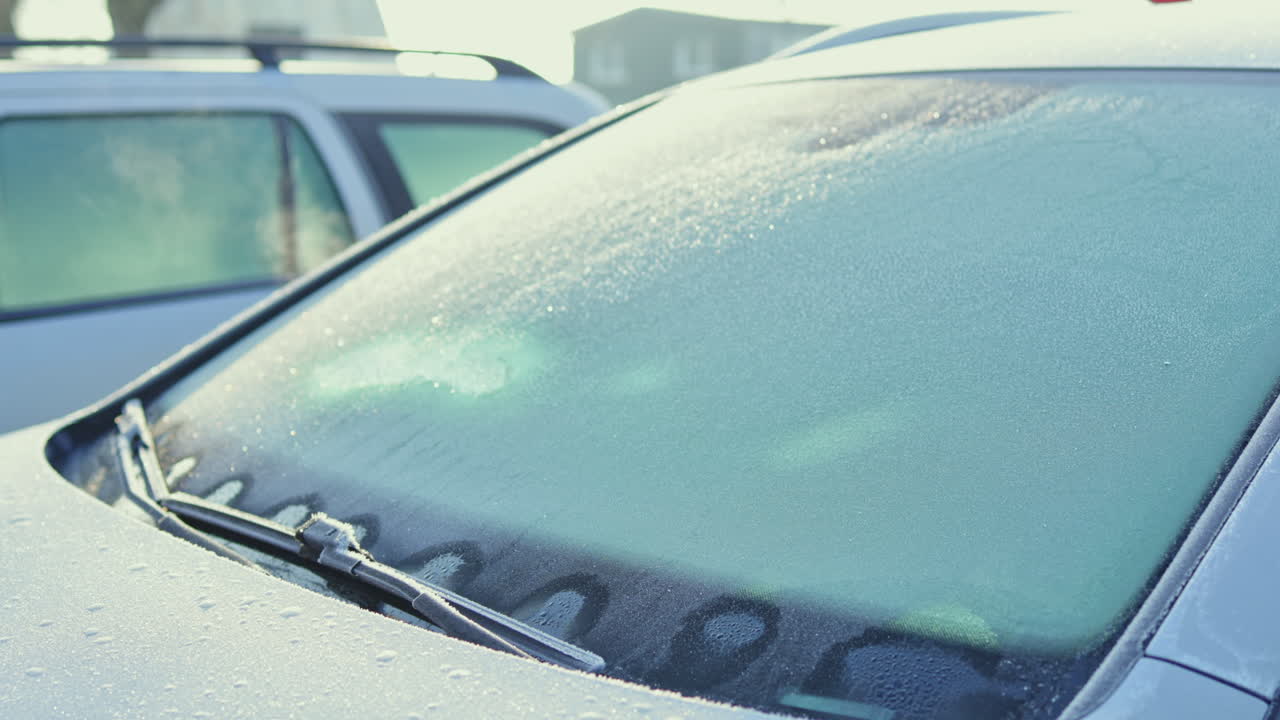 Finestrini dell'auto brinati in una fredda mattina d'inverno creano uno spettacolo visivo mozzafiato con motivi ghiacciati