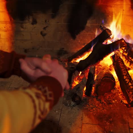 hands of the man closeup. male is warming hands near the bonfire at the twilight's inside. cold season concept