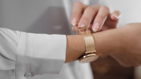 young woman wearing a gold watch, person wearing a gold watch, preparing for an event, 4k footage
