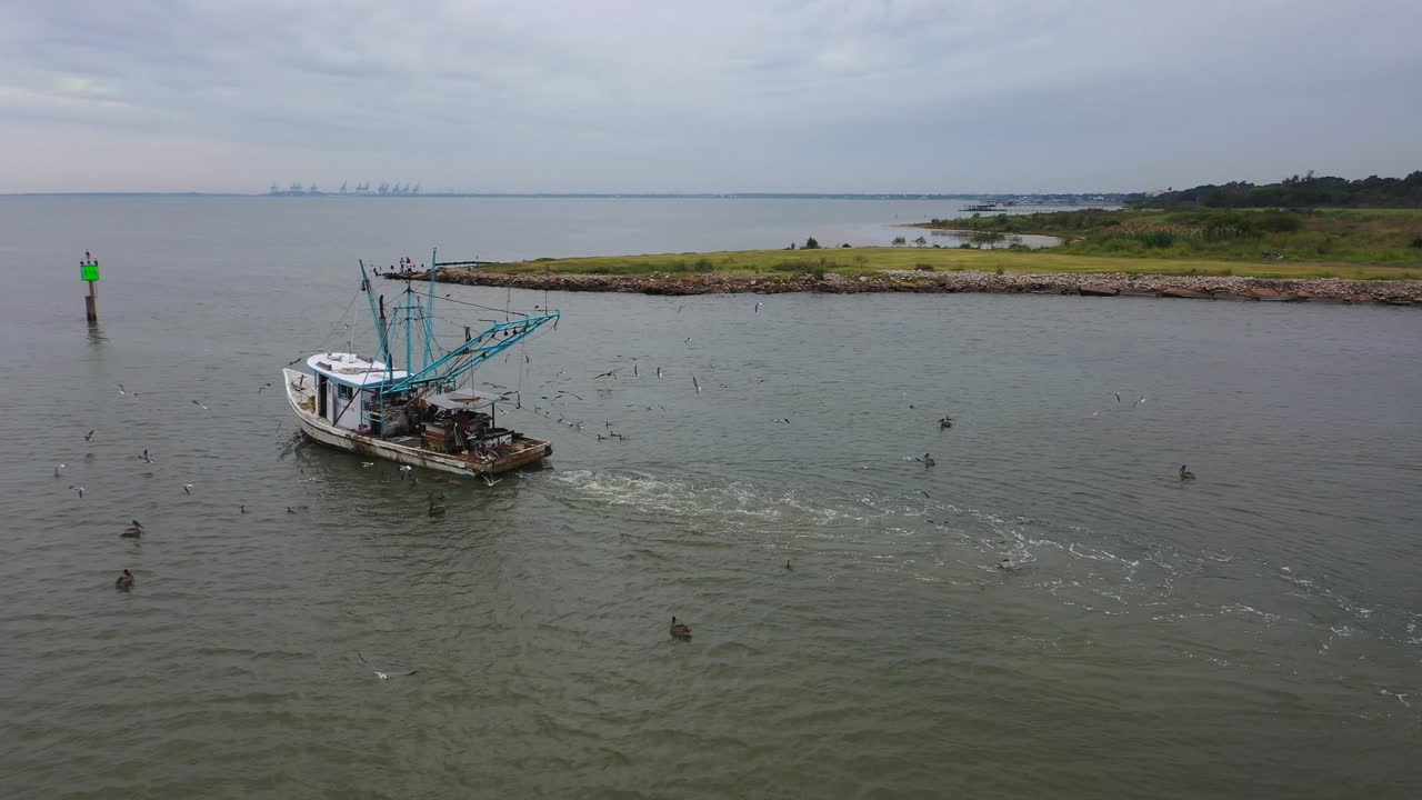 Crevettier chalutant la rivière San Jacinto et navire marchand se dirigeant vers le port