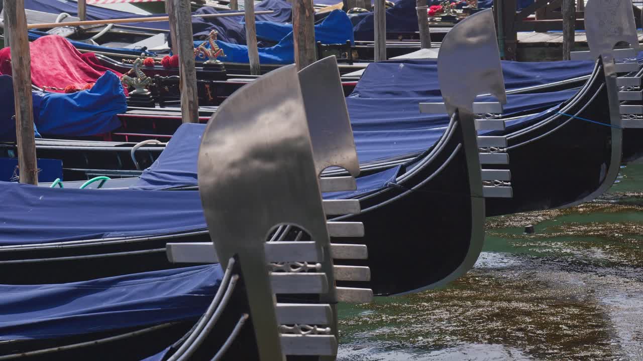 Gros plan sur les gondoles et le rythme de tangage de leurs fers emblématiques sur la lagune de Venise