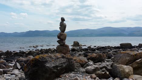 balanced spirituality meditation pebbles piled on alien rocky mountain range beach coastline push in right