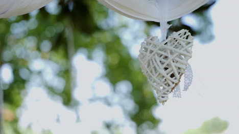 Wooden-woven-heart-decorates-a-petunia-tree-for-wedding-ceremony