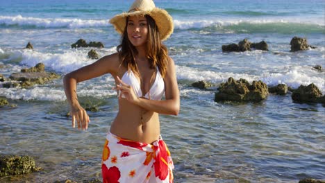 Laughing-young-woman-standing-on-a-rocky-seashore