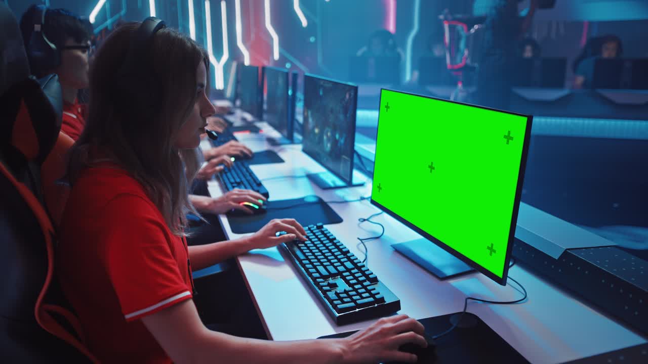 Pro Girl Plays Computer Game with Green Screen Display on a Championship. Diverse Esport Team of Pro Gamers Play in Mock-up Video Game. Stylish Neon Cyber Games Arena. Over The Shoulder