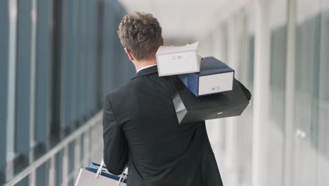 Rear-view-of-an-adult-stylish-man-with-shopping-bags