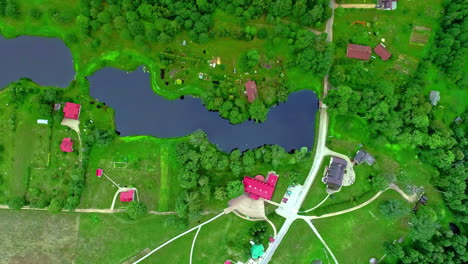 aerial birds eye view over munchhausen museum beside lake in latvia