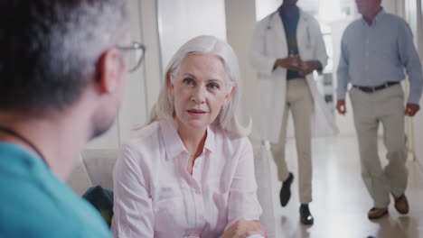 Doctor-Welcoming-To-Senior-Female-Patient-Being-Admitted-To-Hospital