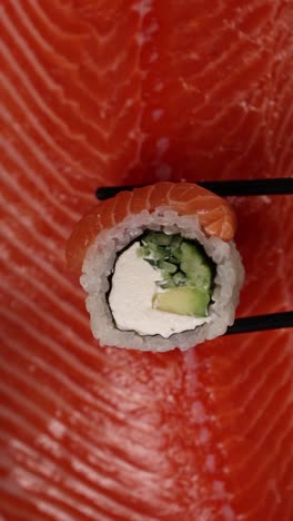 rollo de sushi de salmón con palillos