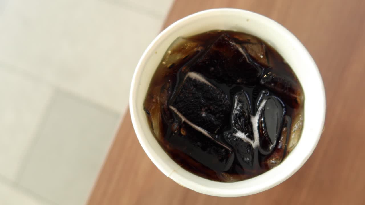 얼음 큐브 가 있는 잔 에 탄산 음료 를  ⁇ 우는 것