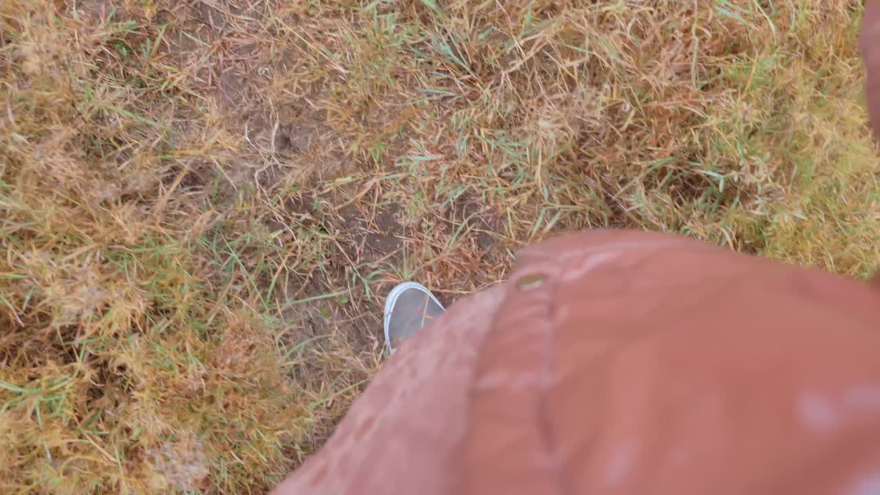 Primo piano di un uomo che cammina attraverso l'erba alta della savana.