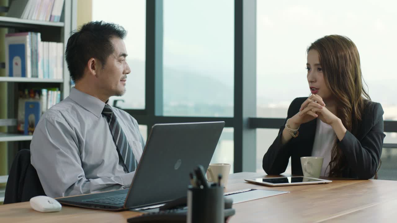 아시아 기업 임원 들 이 사무실 에서 사업 에 대해 논의 하고 있다