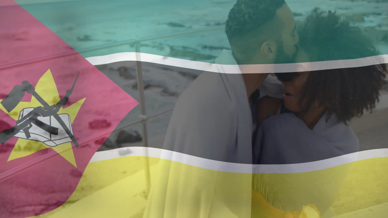Embracing on beach, couple with Mozambique flag animation overlay background