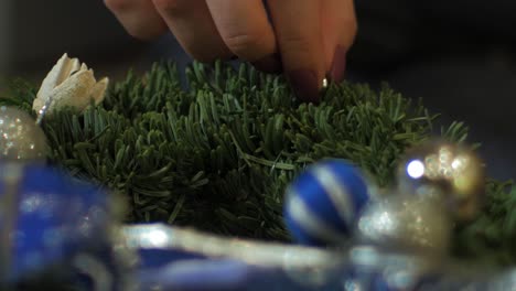 mujer haciendo una corona de adviento de abeto para la víspera de navidad y decorándola con flores blancas secas, decoración artesanal diy, tradiciones de invierno, vacaciones de temporada, manos de cerca