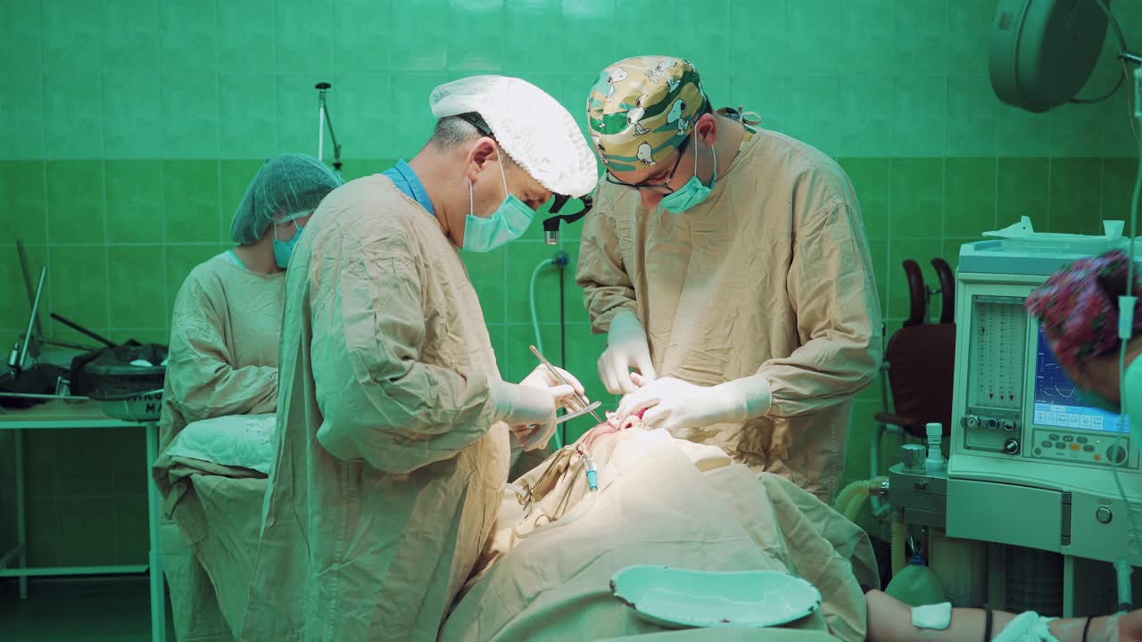 In surgery. Surgeons team performing operation in hospital operating theater.