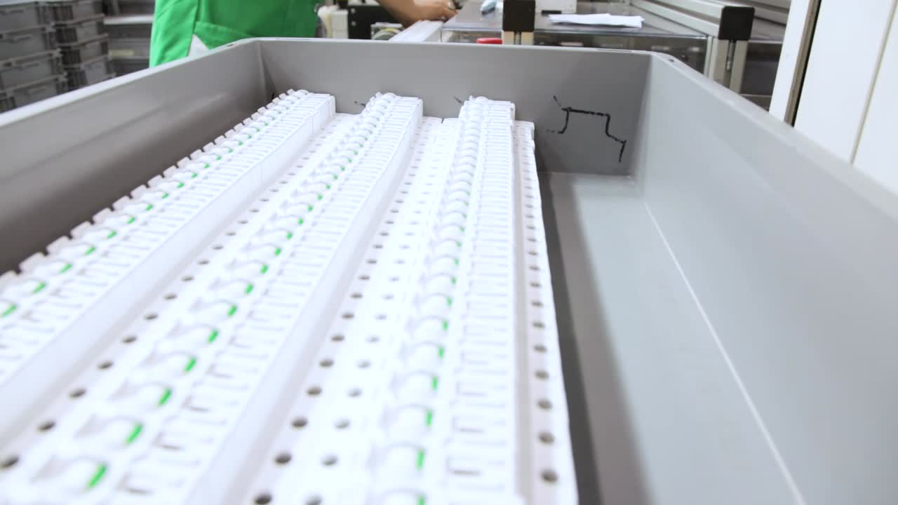 Worker Packing Circuit Breakers From Into Grey Tray Box. Low Angle Shot