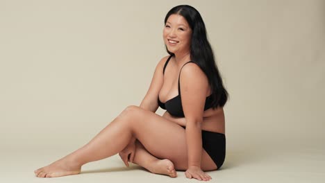 chinese woman in underwear sitting on the floor in the studio