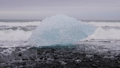 waves crashing on iceberg at breidamerkursandur - diamond beach, south iceland