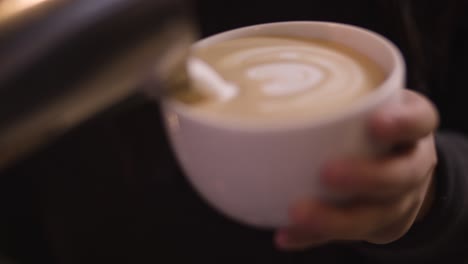 barista makes latte art close up