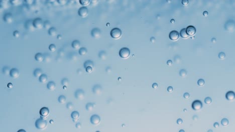 Many-water-bubbles-in-blue-water-close-up,-abstract-water-wave-with-bubbles-in-slow-motion.