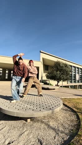 young couple dancing a choreography outdoors in university campus