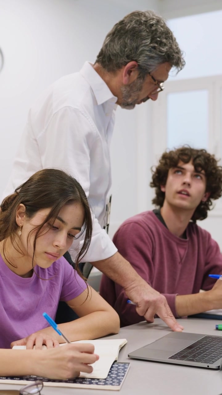 Insegnante che guida gli studenti con il laptop in classe