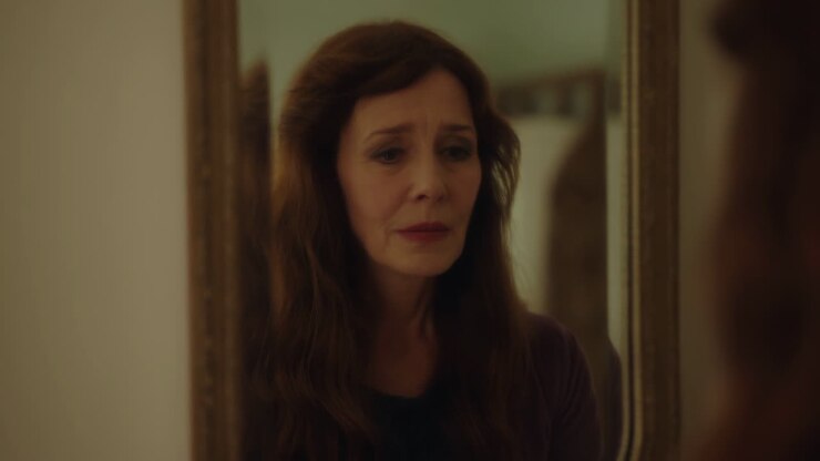 Emotional Woman Looks at Her Aging Reflection in a Mirror