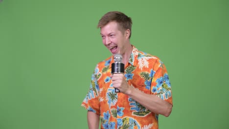 young handsome tourist man talking on microphone and showing something