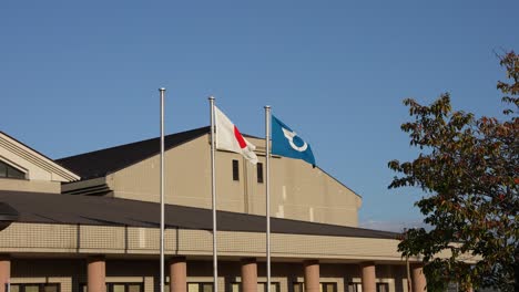 Japan-and-Shiga-Prefecture-Flag-Flying-over-Building-in-Slow-Motion