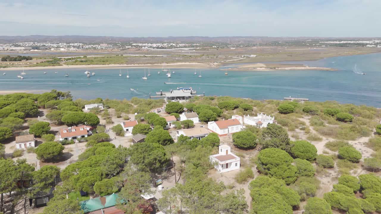 Scenic drone view of Tavira Island featuring quaint houses surrounded by natural beauty and river views