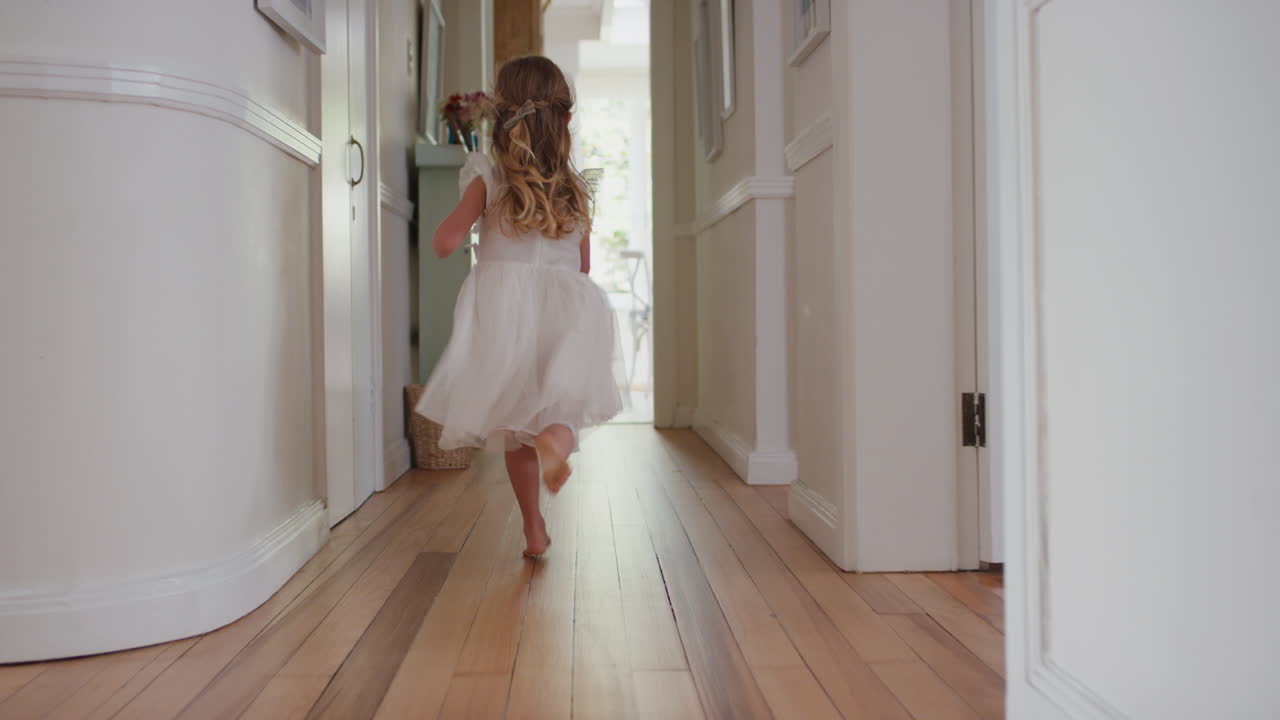 счастливая маленькая девочка бегает по дому, увлекается игрой на улице, веселится в выходные утром, наслаждается ношением красивого белого платья 4к