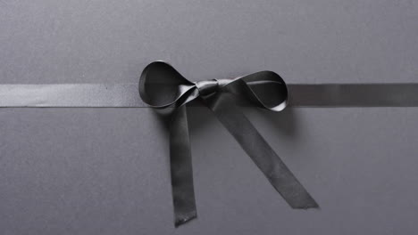 Video-of-black-gift-ribbon-and-bow-with-copy-space-on-black-background