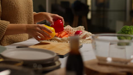 un primer plano de una mujer llegando a casa de las compras de comida desempaquetando una bolsa de verduras frescas en el mostrador de la cocina 1