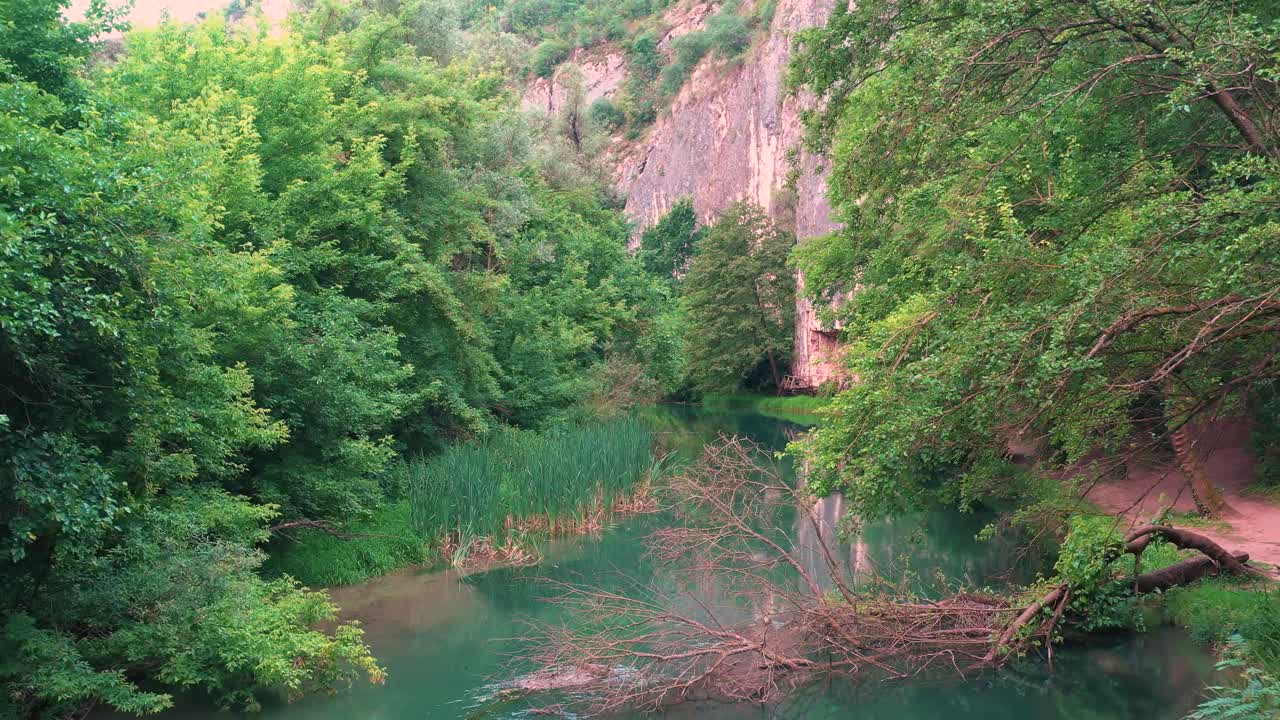 volando hacia atrás sobre el río panega rodeado de árboles en el geoparque iskar-panega