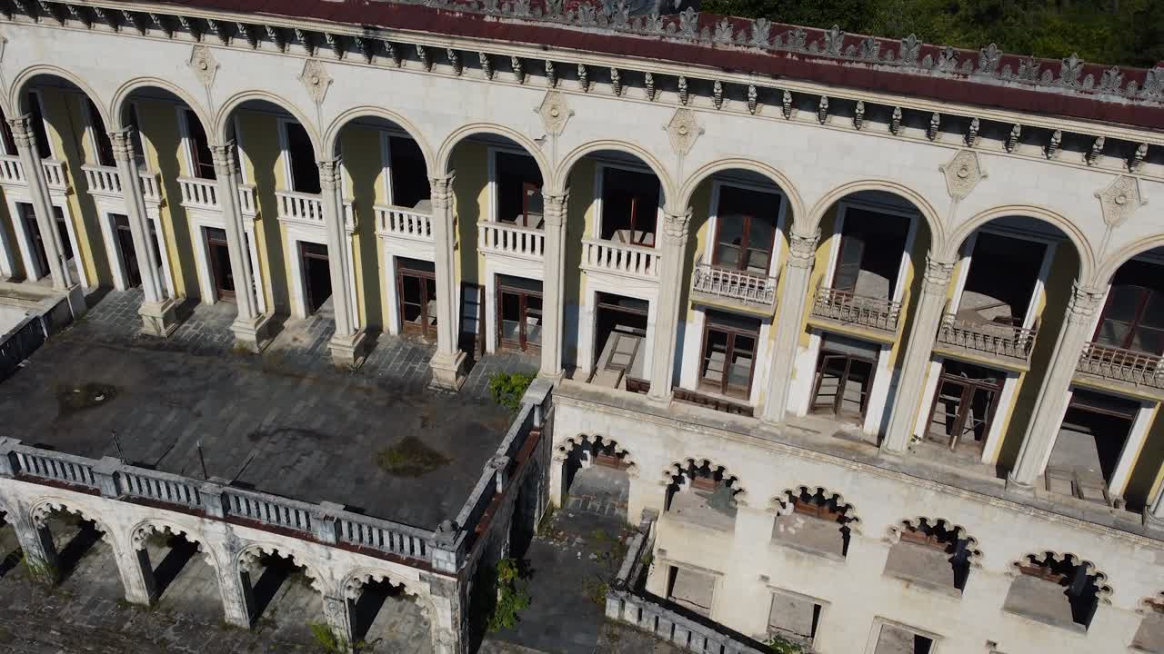 Aerial of decaying facade of grand Tskaltubo spa with ornate columns and balconies