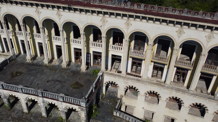 Vista aerea della facciata fatiscente del grandioso centro benessere di Tskaltubo, con colonne e balconi decorati