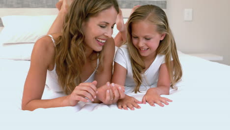 Mother-and-daughter-lying-on-their-bed